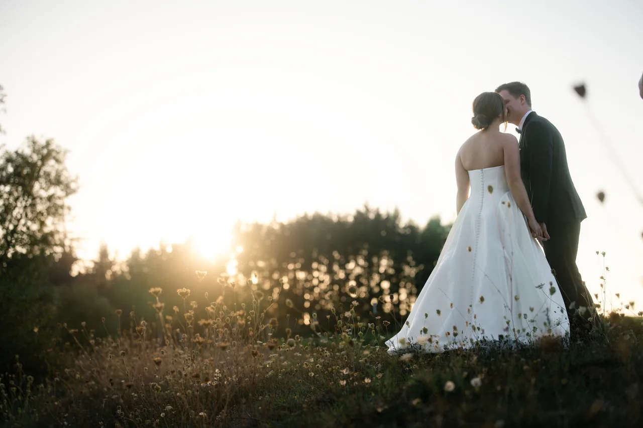 Jayde and Brock kiss among meadow flowers at The Farm on Golden Hill.