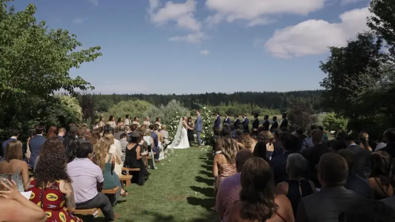 An outdoor wedding ceremony viewed from the center aisle